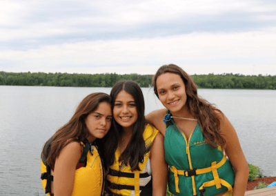 Three girls in life jackets posing for a picture.