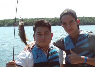 Two young men holding up a fish on a dock.