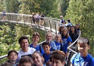 A group of young people standing on a bridge.
