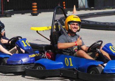 Two men riding go - karts on a track.