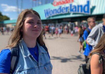 A girl in a denim jacket standing in front of a canadian wonderland.