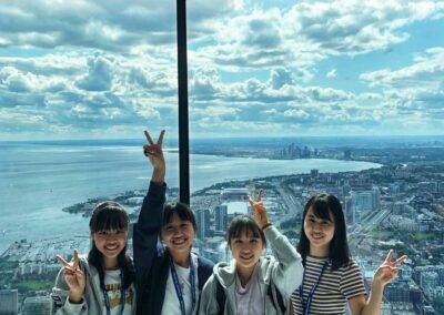 A group of girls posing for a picture in front of a tall building.