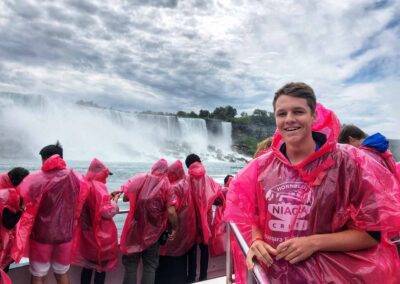 A group of people in pink raincoats standing in front of niagara falls.