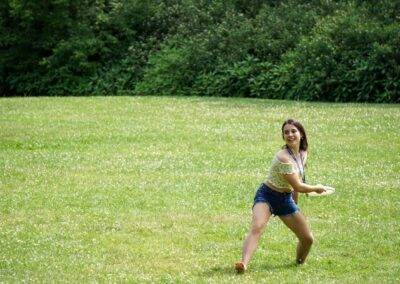 A woman is playing frisbee in a field.