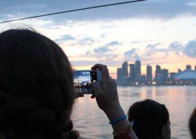 A group of people taking a picture of the cn tower at sunset.
