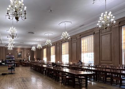 A large dining room with wooden tables and chandeliers.